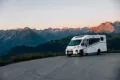 V 67S Adventure bei Sonnenuntergang und im Hintergrund ist eine Bergkette.